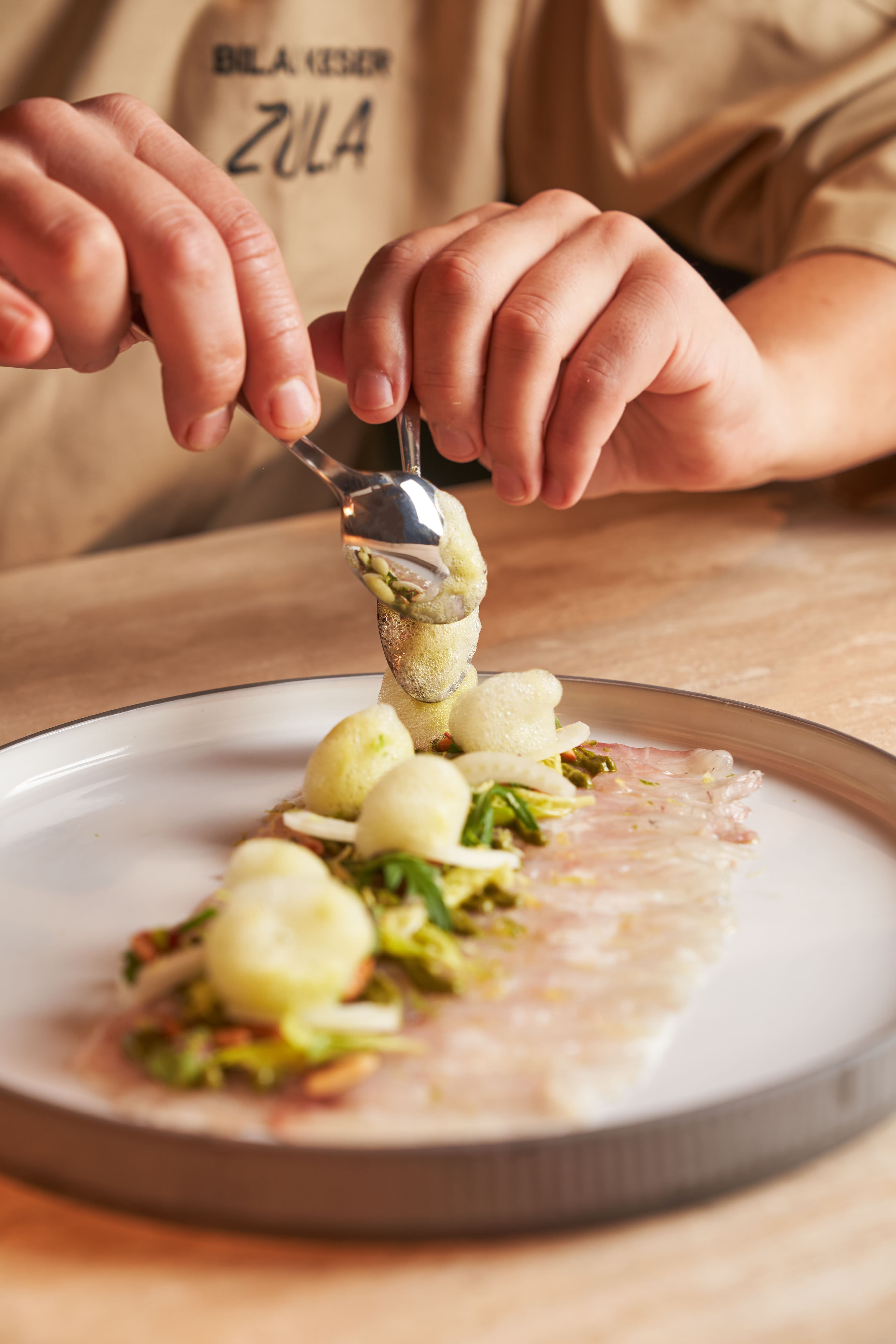 A chef plating a dish in the kitchen before a departure